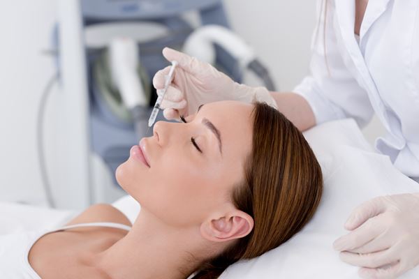 Woman receiving injections to smooth out wrinkles which is a common face rejuvenation treatment.